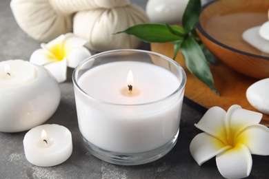 Photo of Beautiful spa composition with candles and flowers on grey background