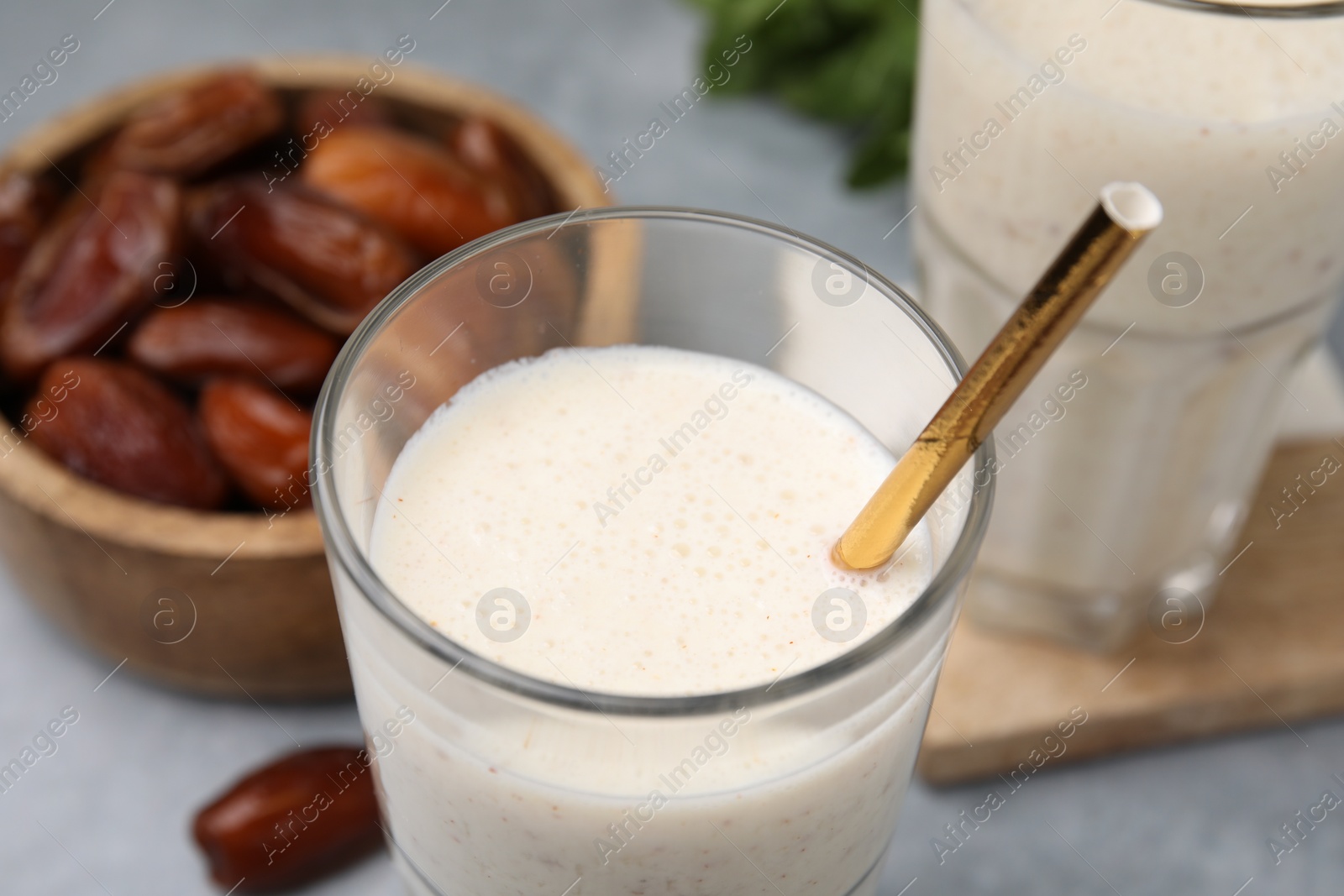 Photo of Glass of delicious date smoothie and dried fruits on table, closeup