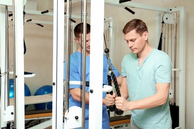 Photo of Patient exercising under physiotherapist supervision in rehabilitation center
