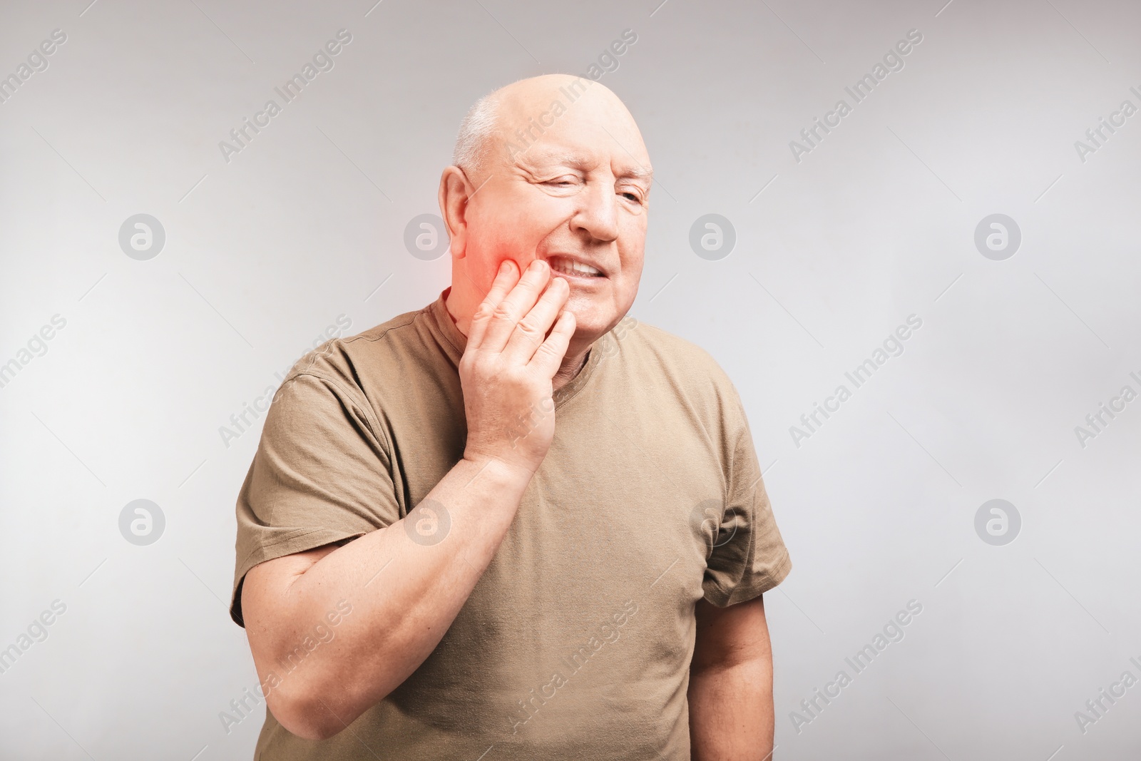 Image of Senior man suffering from toothache on grey background