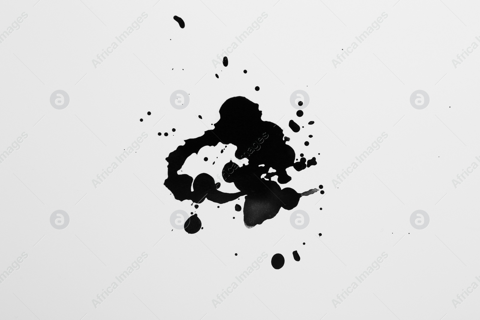 Photo of Blots of black ink on white background, top view