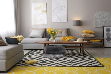 Stylish living room interior with comfortable sofa. Interior design in grey and yellow colors