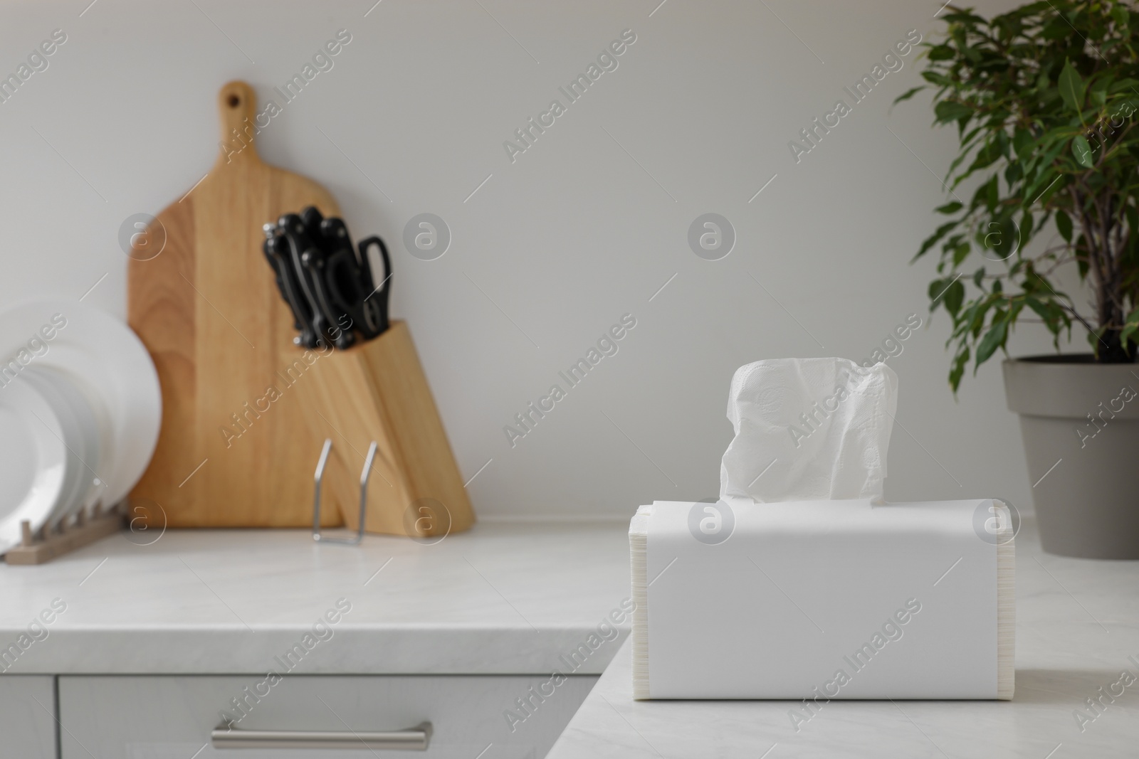 Photo of Package of paper towels on white countertop in kitchen. Space for text