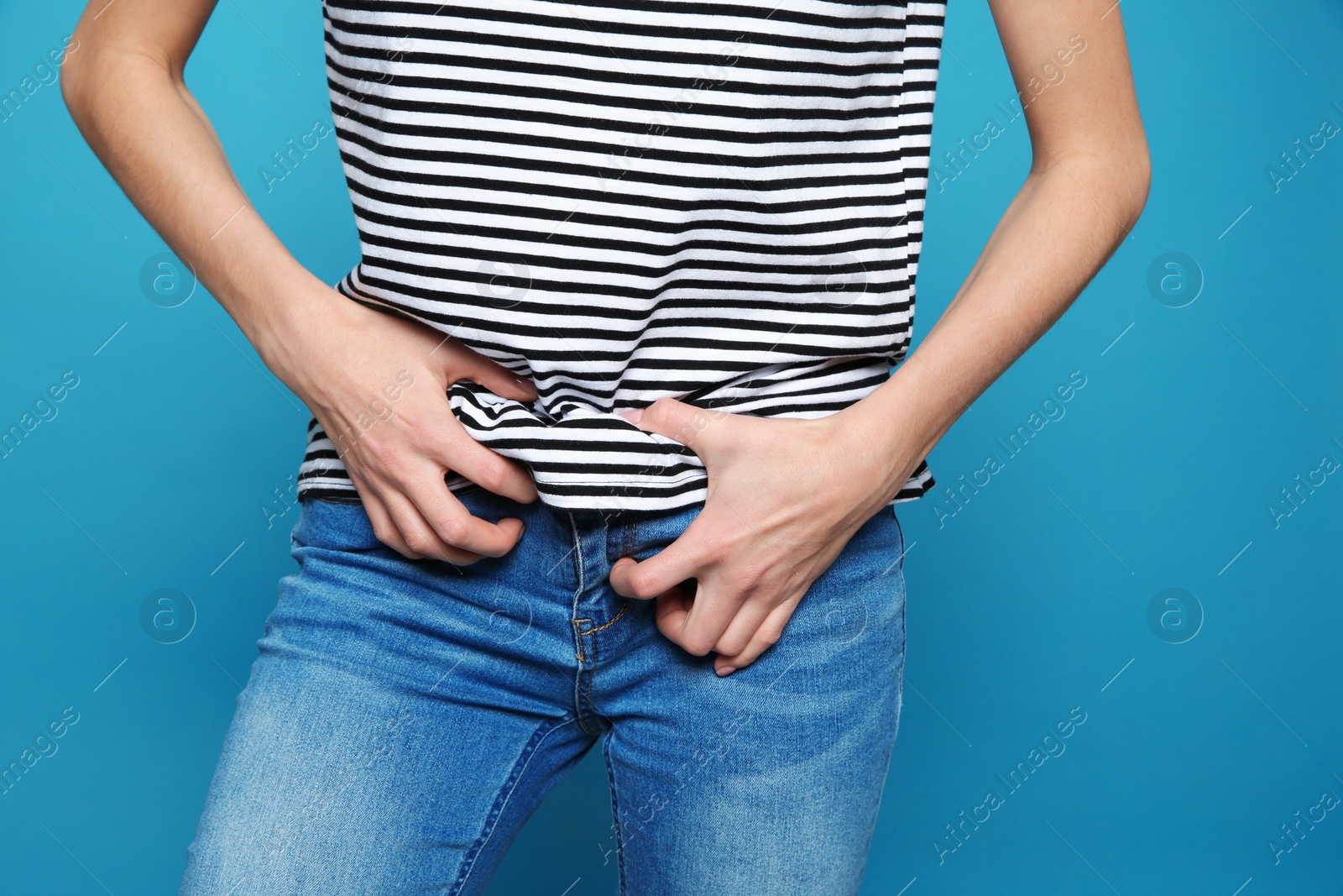 Photo of Woman scratching crotch on color background, closeup. Annoying itch