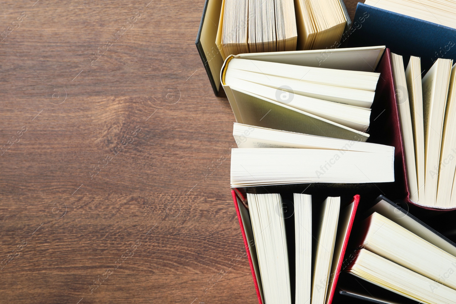 Photo of Hardcover books on wooden table, flat lay. Space for text