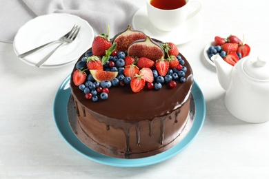 Photo of Fresh delicious homemade chocolate cake with berries on light table