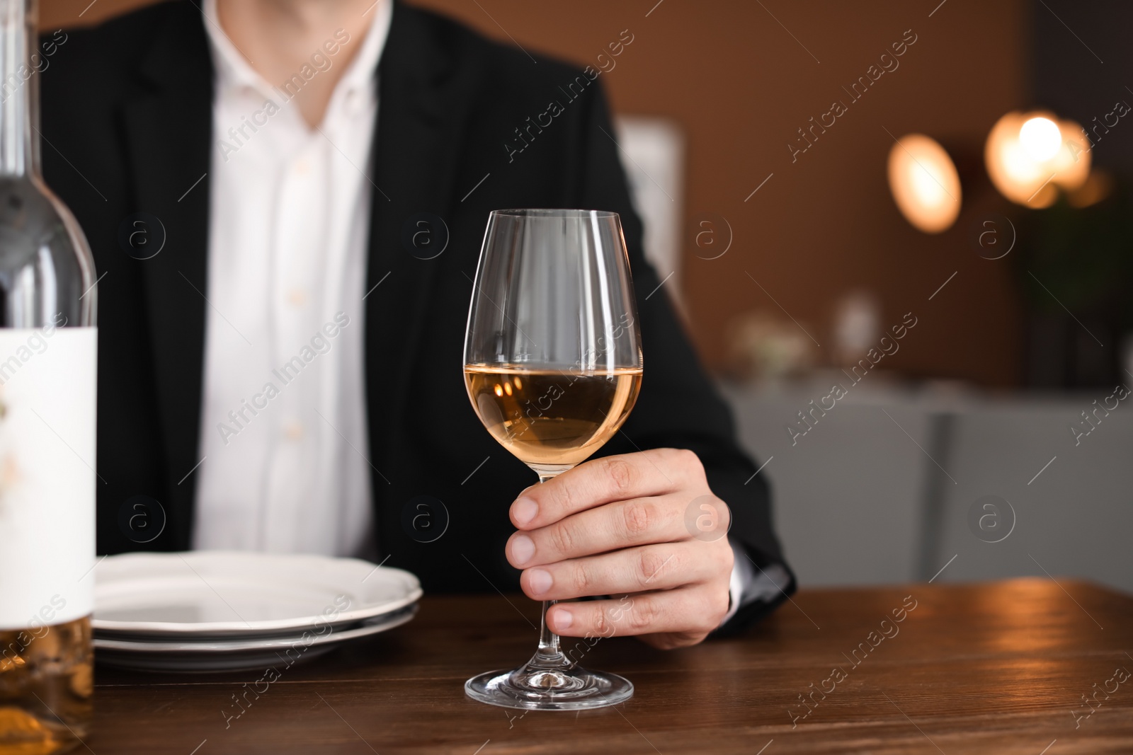 Photo of Man with glass of wine at table in restaurant