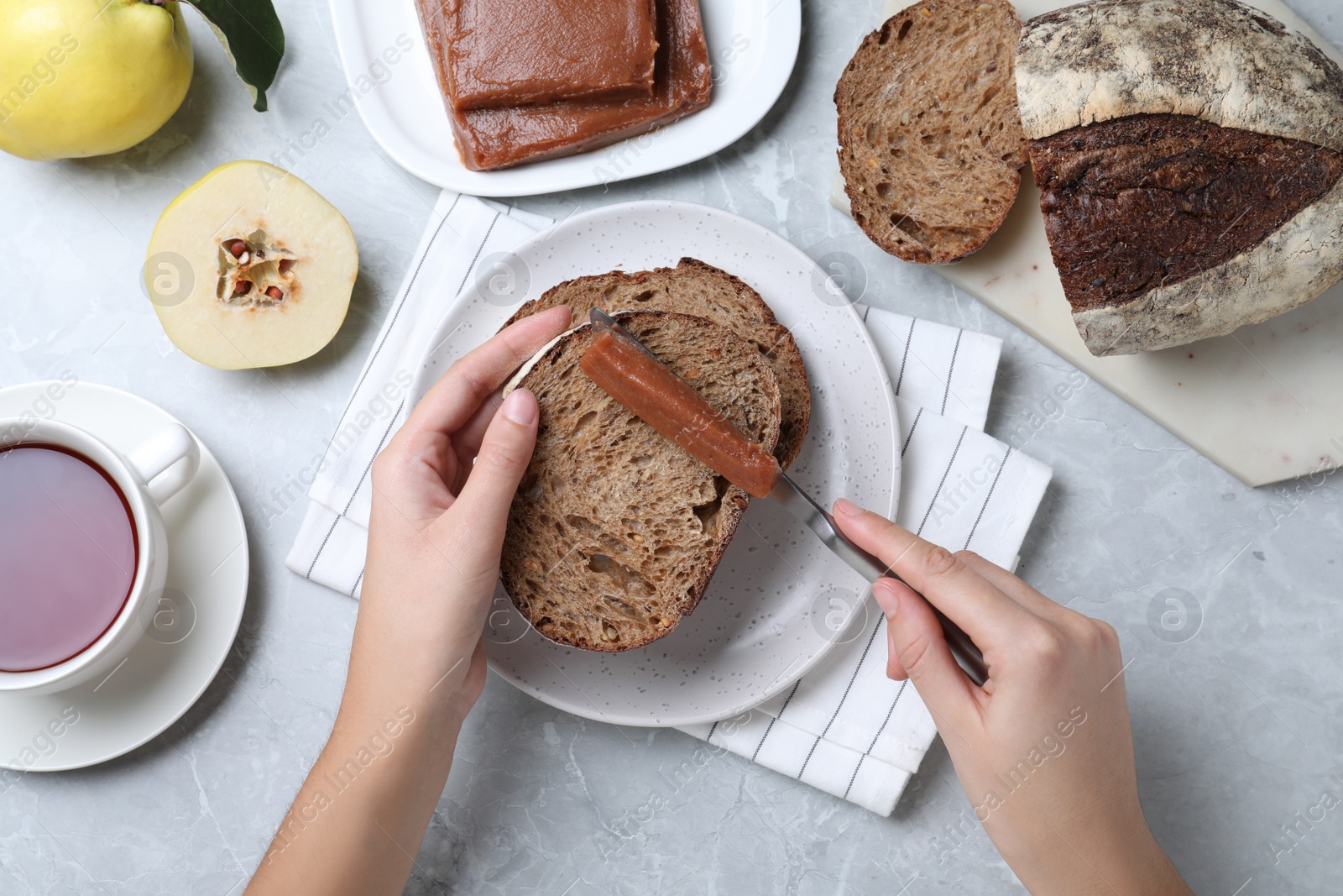 Photo of Woman making sandwich with quince paste at table, top view