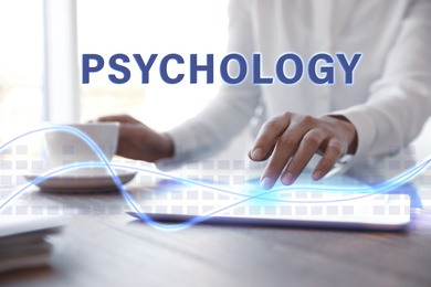 Image of Psychologist working with modern tablet at wooden table in office, closeup 