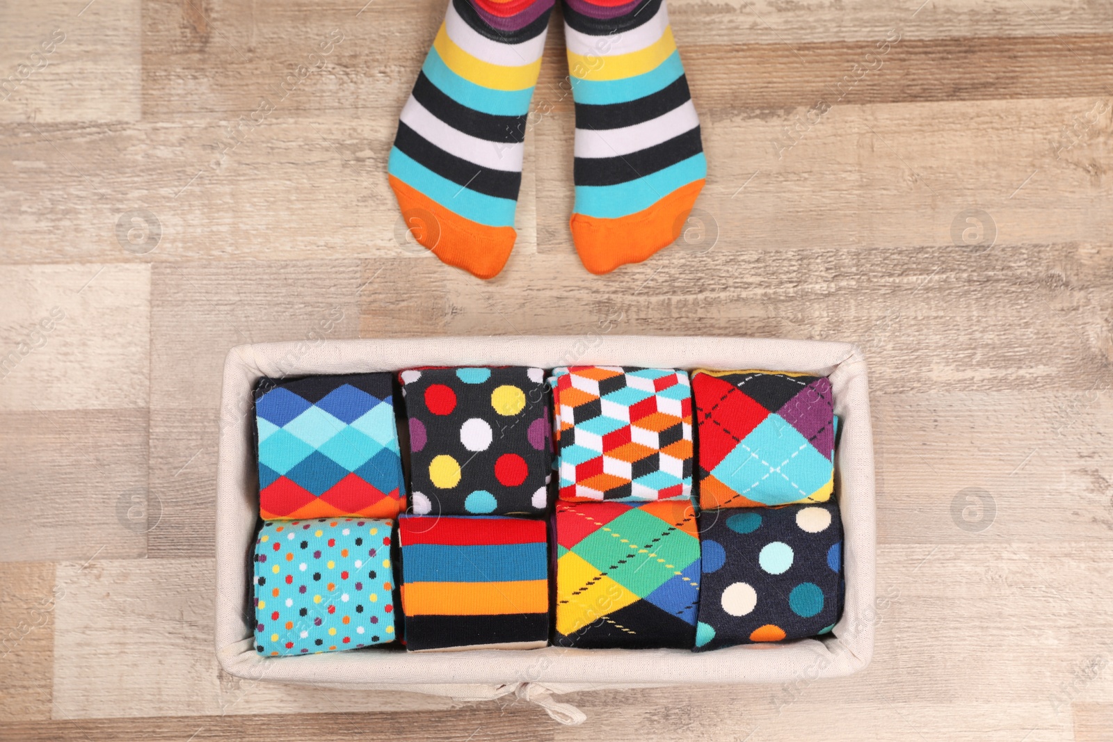 Photo of Woman with different socks standing on floor, top view