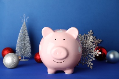 Composition with piggy bank and Christmas decor on color background