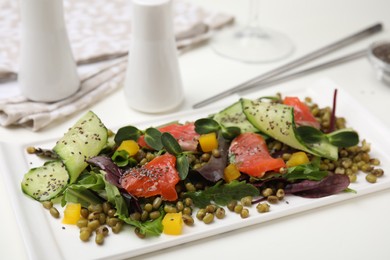 Plate of salad with mung beans on white table