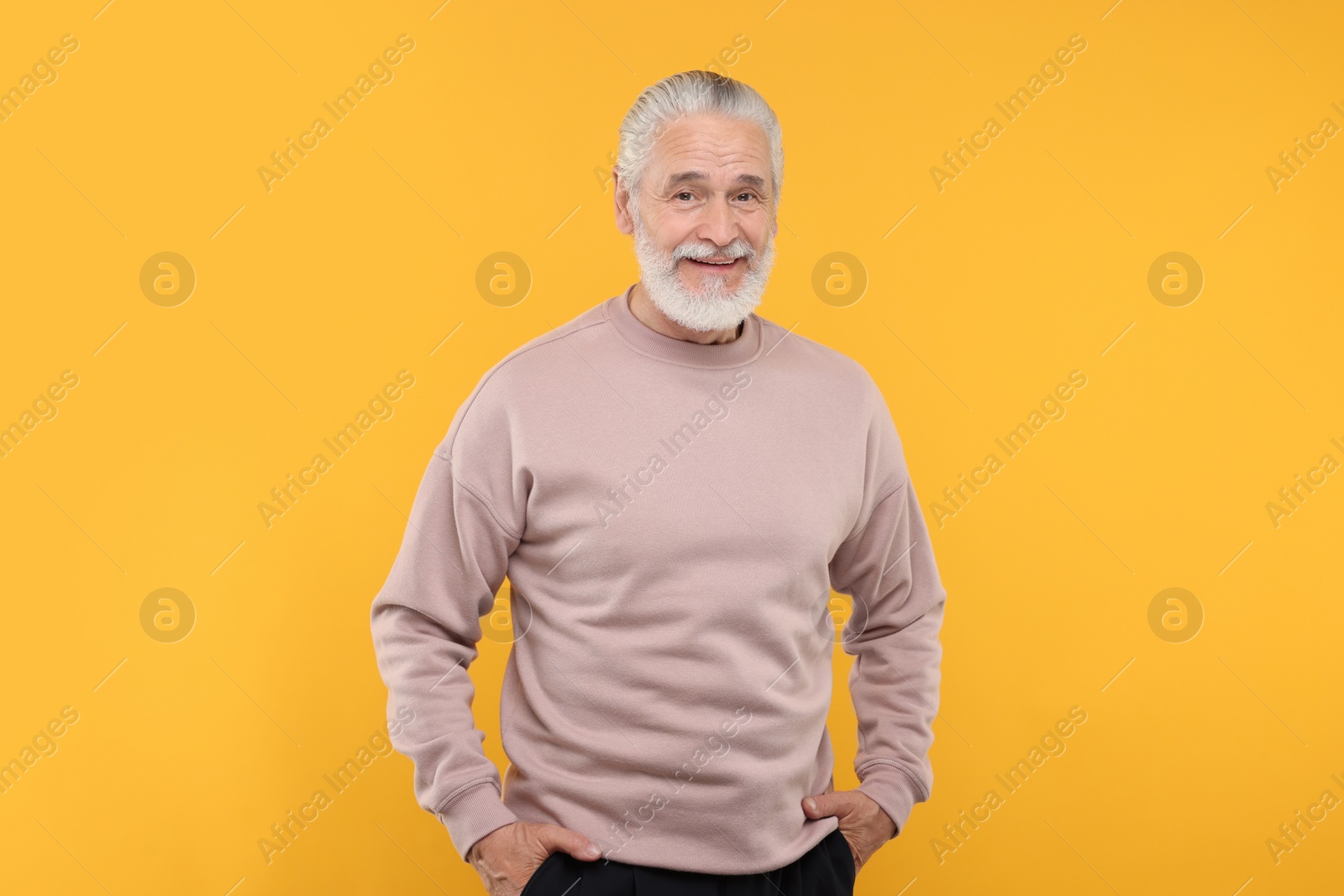 Photo of Portrait of handsome senior man on orange background