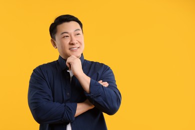 Portrait of happy man on yellow background. Space for text