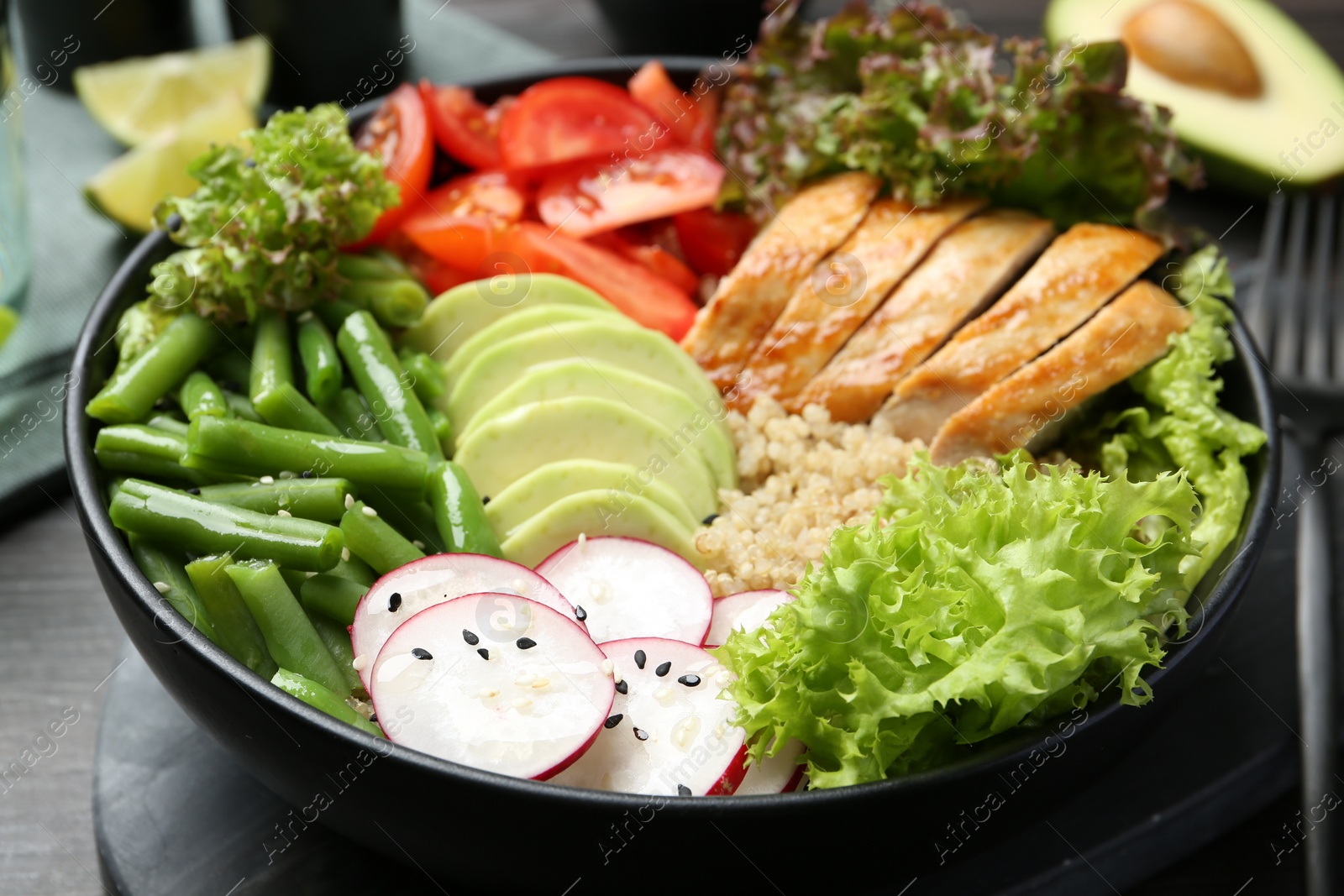 Photo of Healthy meal. Tasty products in bowl on black wooden table, closeup