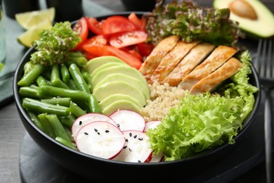 Healthy meal. Tasty products in bowl on black wooden table, closeup