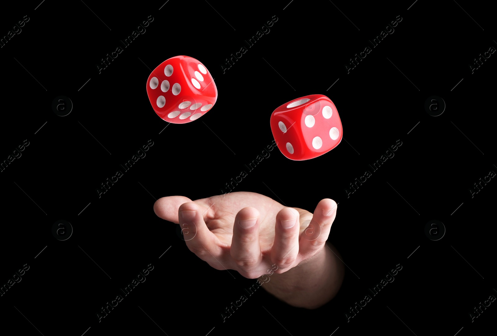 Image of Man throwing red dice on black background, closeup