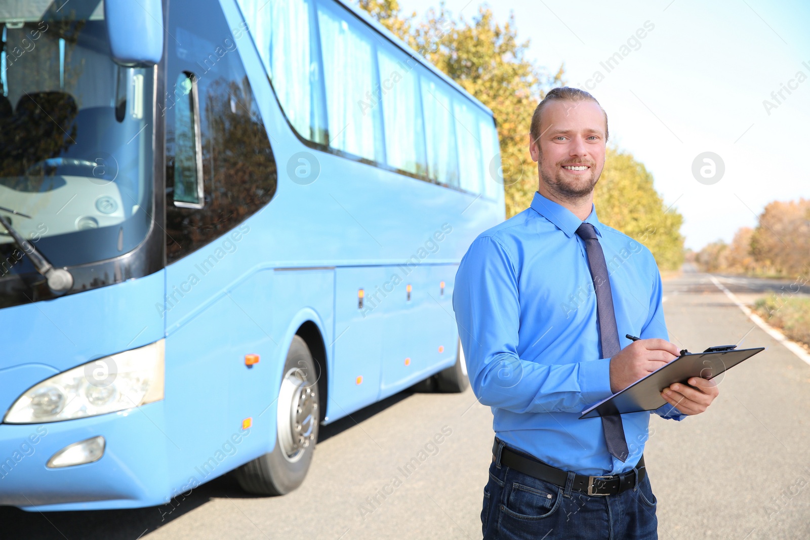 Photo of Professional driver with clipboard near bus. Passenger transportation