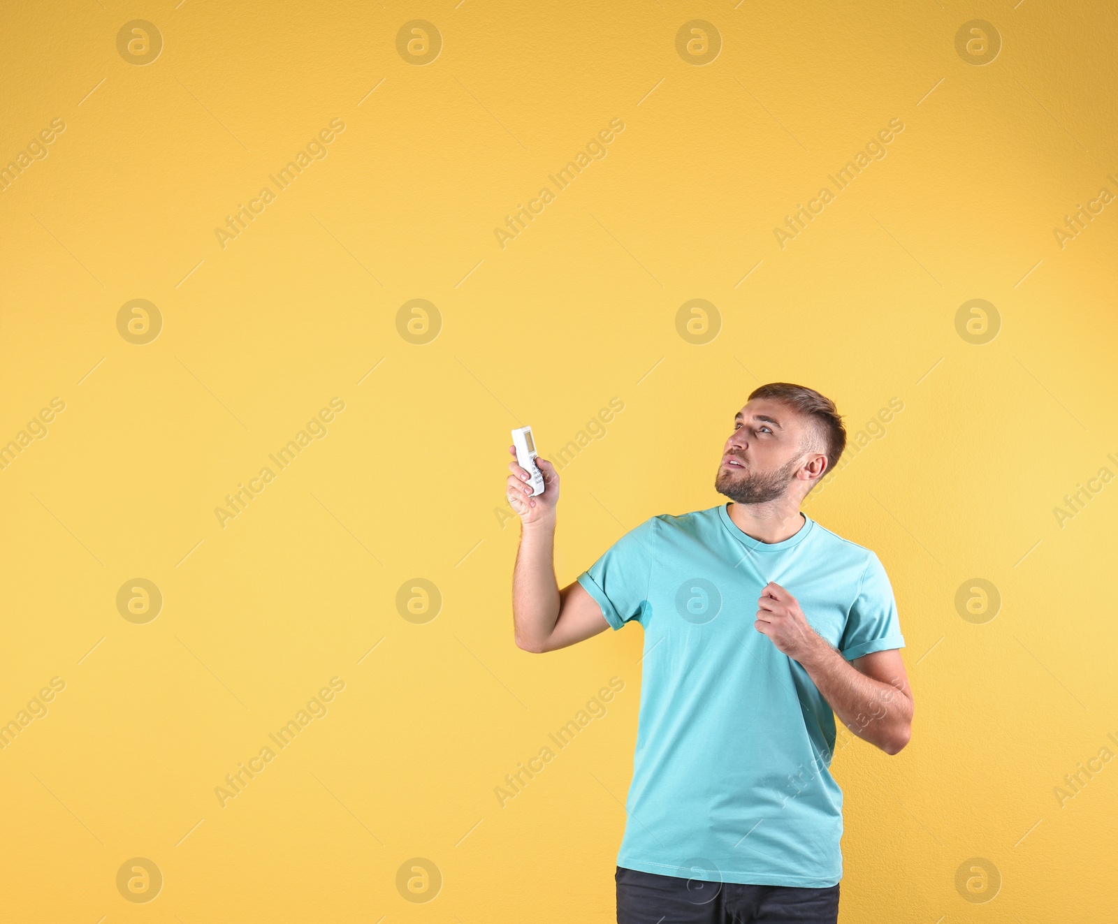 Photo of Young man suffering from heat on color background with copy space text. Air conditioner malfunction