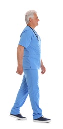 Photo of Full length portrait of male doctor in scrubs with stethoscope isolated on white. Medical staff