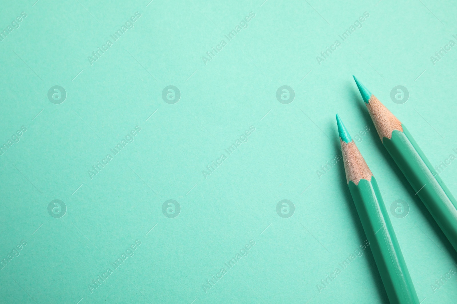 Photo of Flat lay composition with color pencils on turquoise background. Space for text