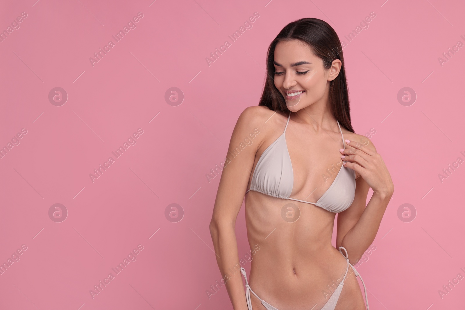 Photo of Young woman in stylish bikini on pink background, space for text