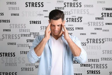 Stressed young man and text on light background
