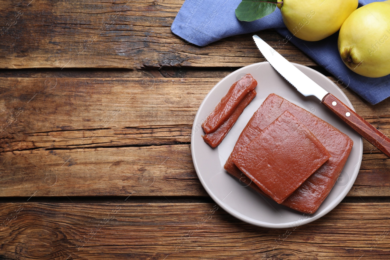 Photo of Quince paste on wooden table, flat lay. Space for text