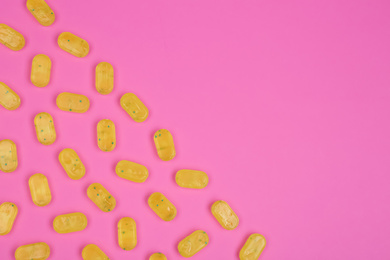 Photo of Many delicious lemon drops on pink background, flat lay. Space for text