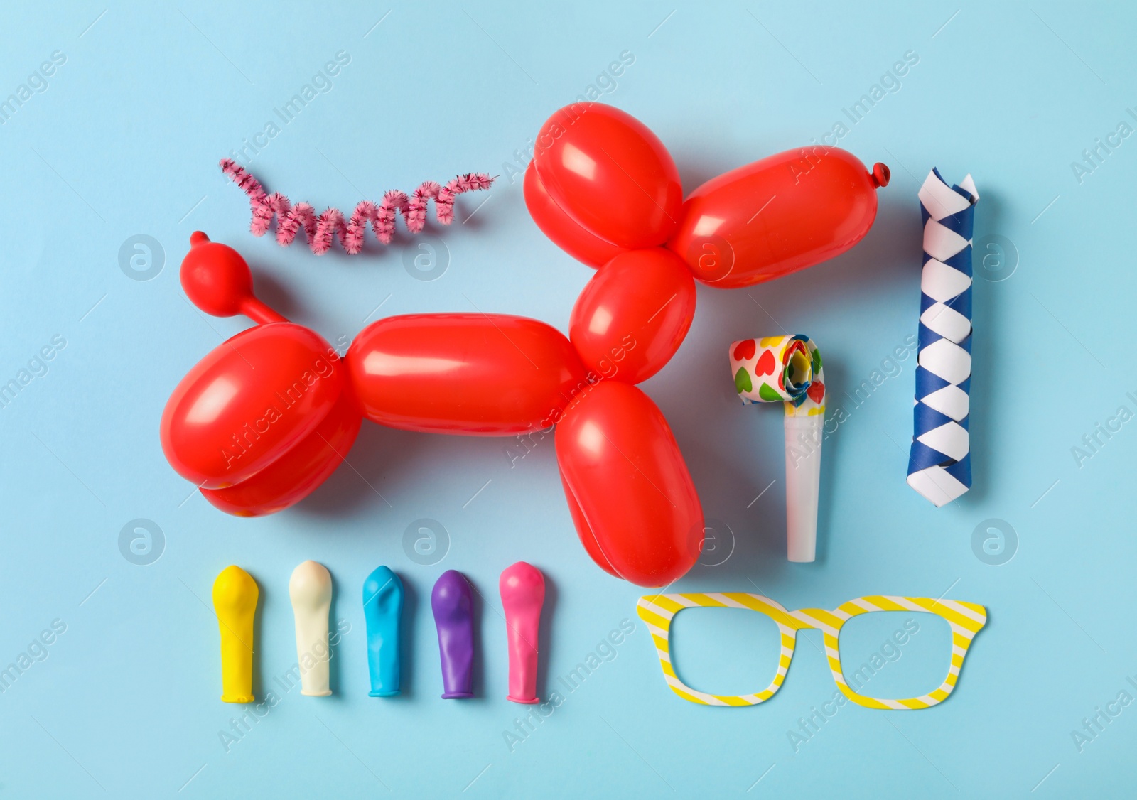 Photo of Different clown's accessories on light blue background, flat lay