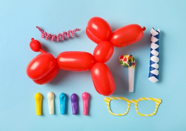 Different clown's accessories on light blue background, flat lay