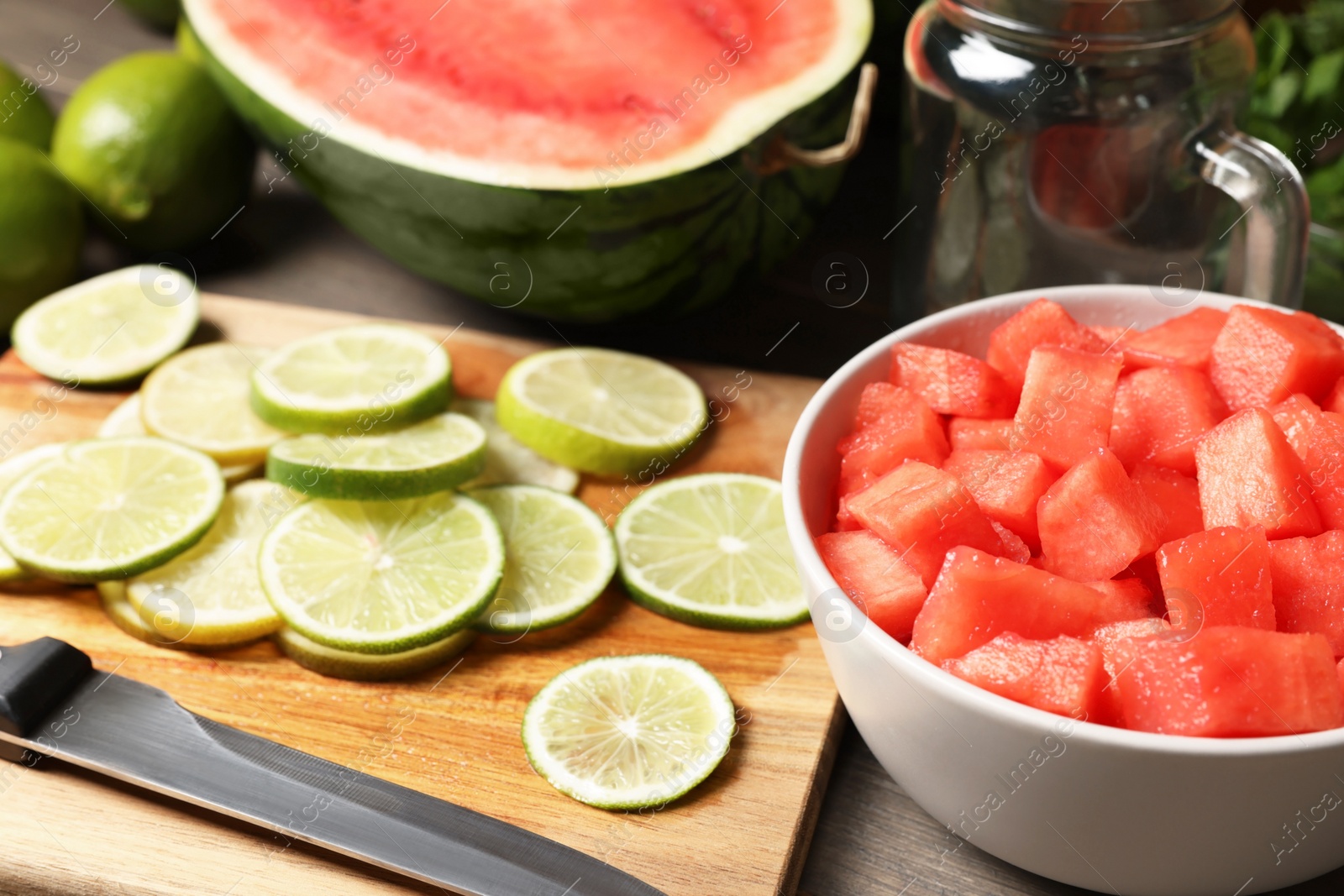 Photo of Fresh ingredients for making watermelon drink with lime on wooden table, closeup
