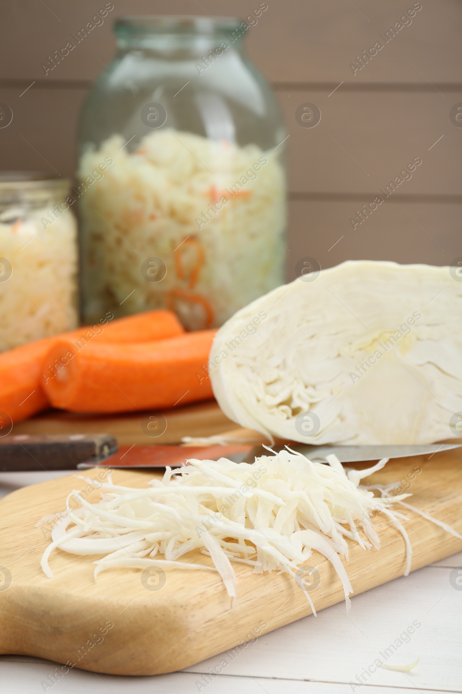 Photo of Cooking delicious sauerkraut soup. Fresh chopped cabbage and ingredients on white table