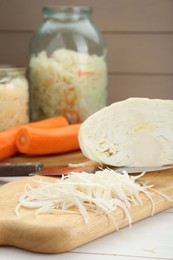 Cooking delicious sauerkraut soup. Fresh chopped cabbage and ingredients on white table