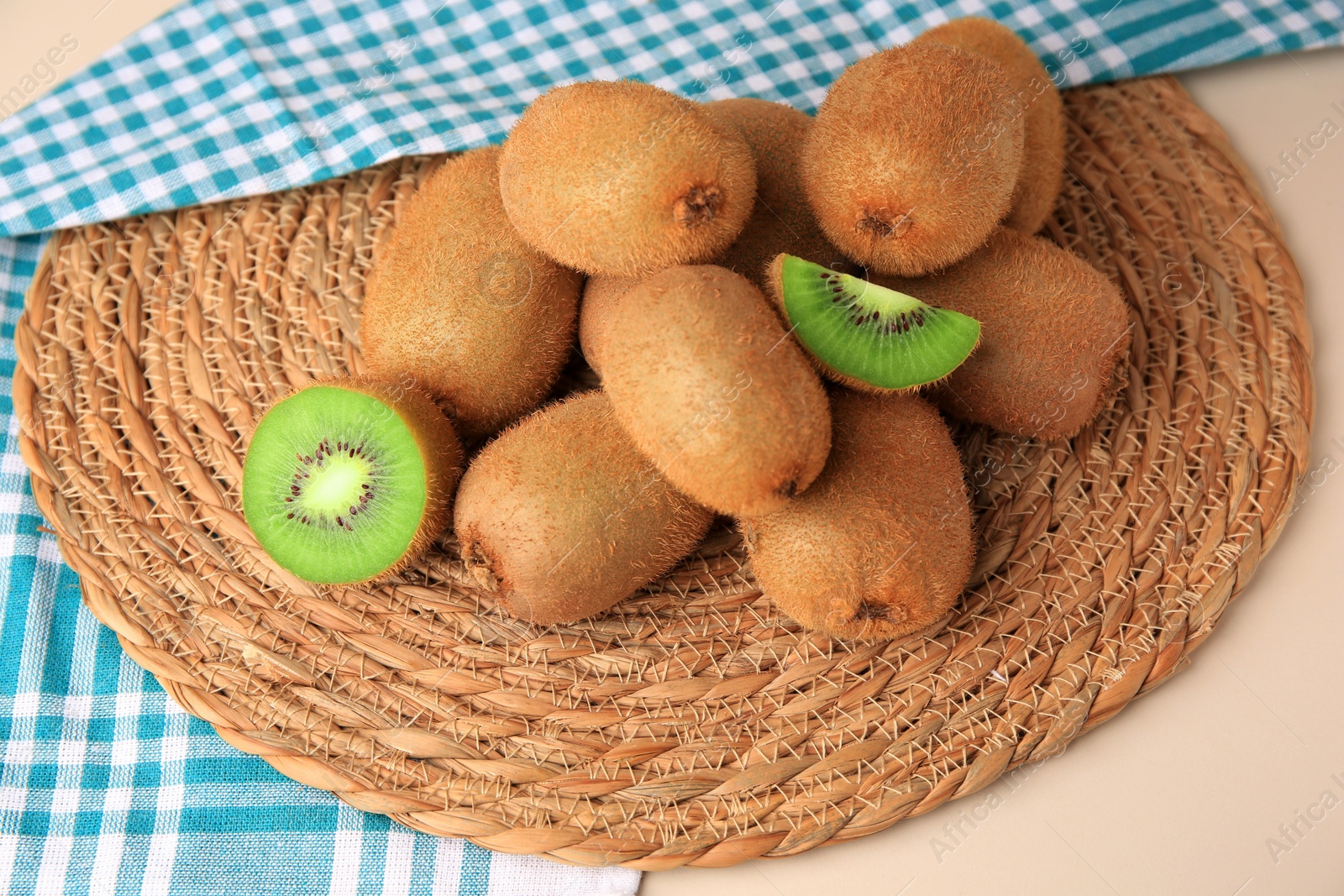 Photo of Heap of whole and cut fresh kiwis on white table