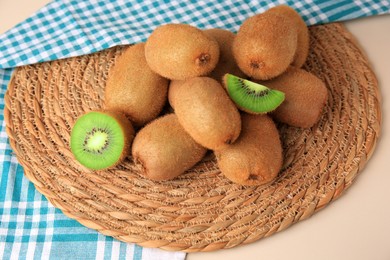 Heap of whole and cut fresh kiwis on white table