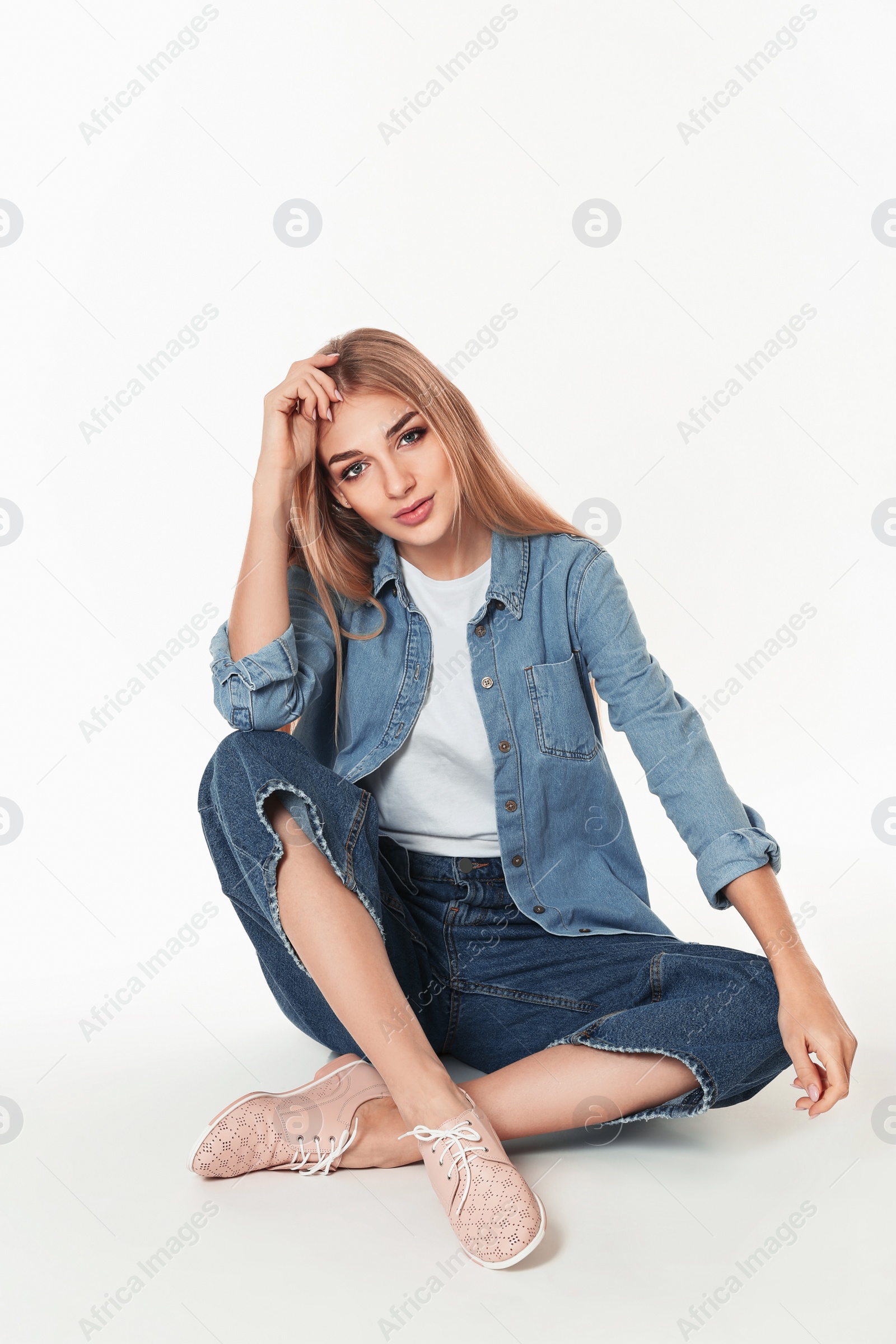 Photo of Fashionable woman in stylish shoes sitting on white background