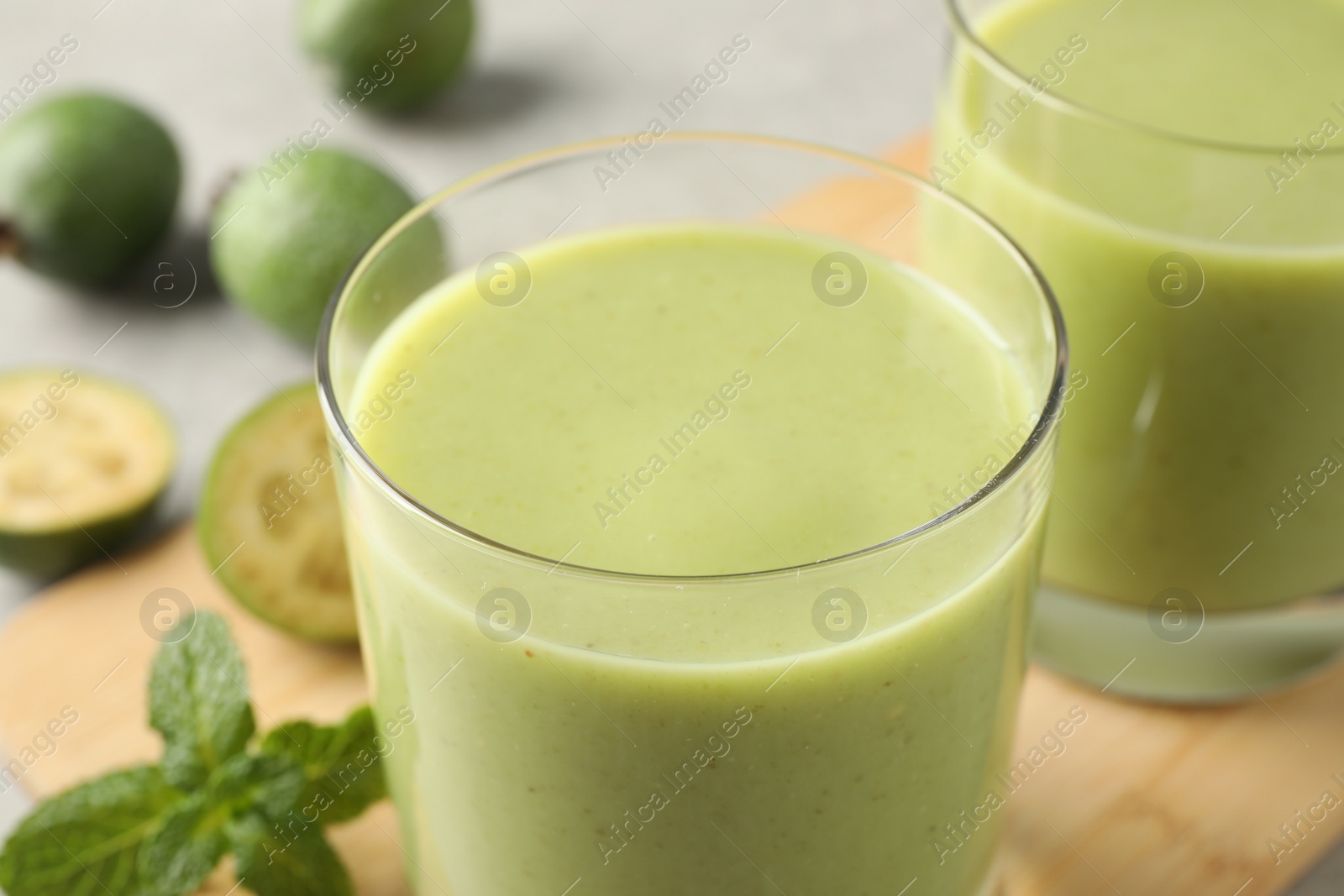 Photo of Fresh feijoa smoothie in glass on table, closeup view