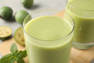 Fresh feijoa smoothie in glass on table, closeup view