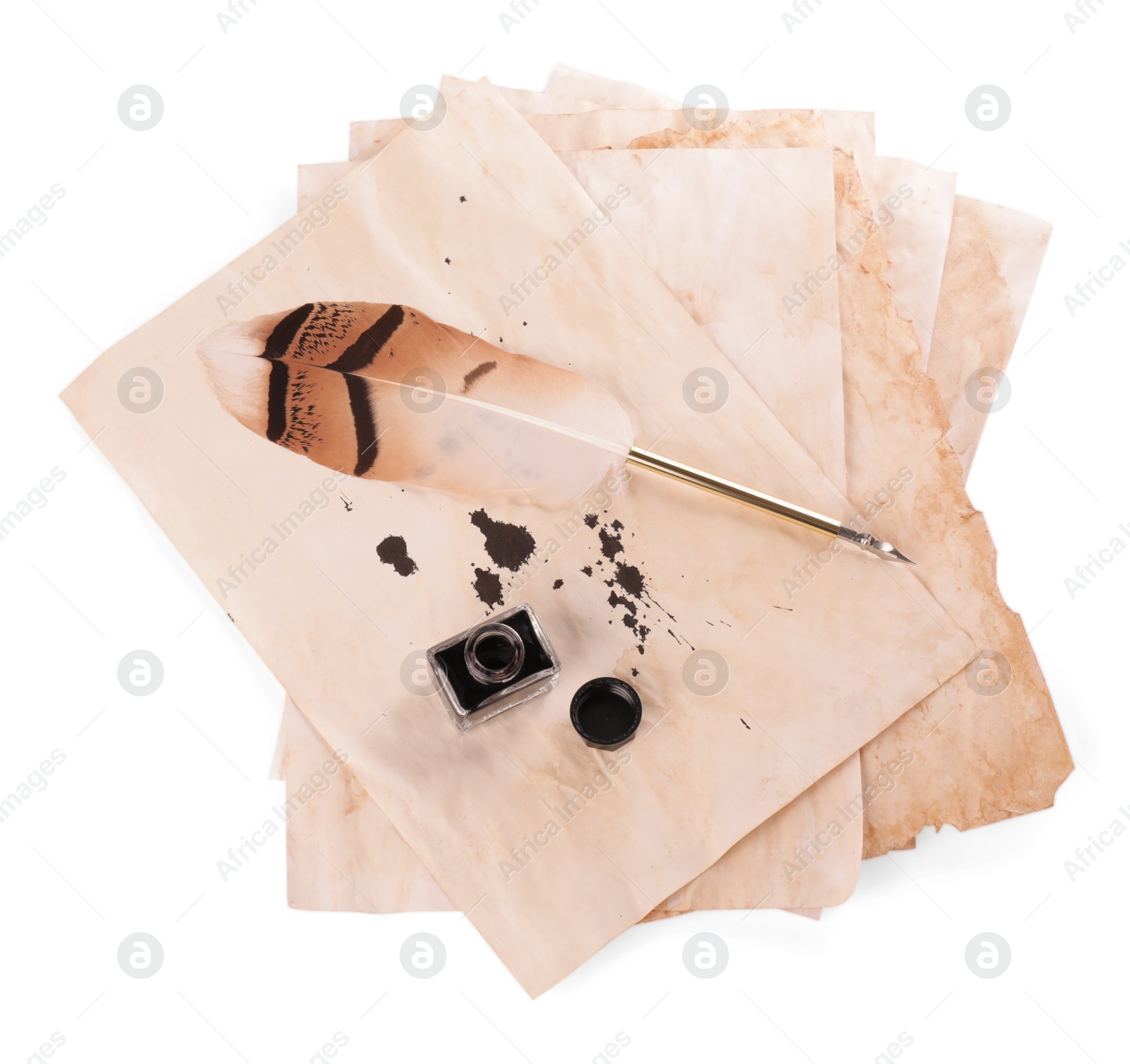 Photo of Parchment with stains of ink, feather pen and inkwell on white background, top view