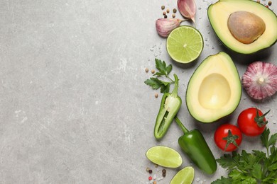 Fresh guacamole ingredients on light grey table, flat lay. Space for text