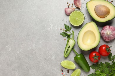 Photo of Fresh guacamole ingredients on light grey table, flat lay. Space for text