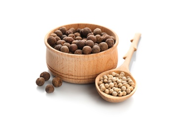 Bowl and spoon with pepper grains on white background