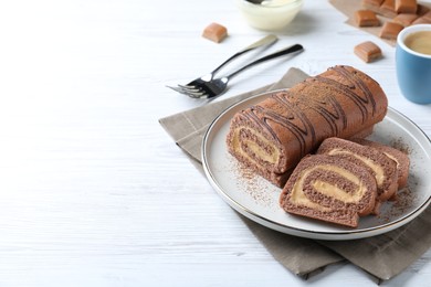 Tasty chocolate cake roll with cream on white wooden table, space for text