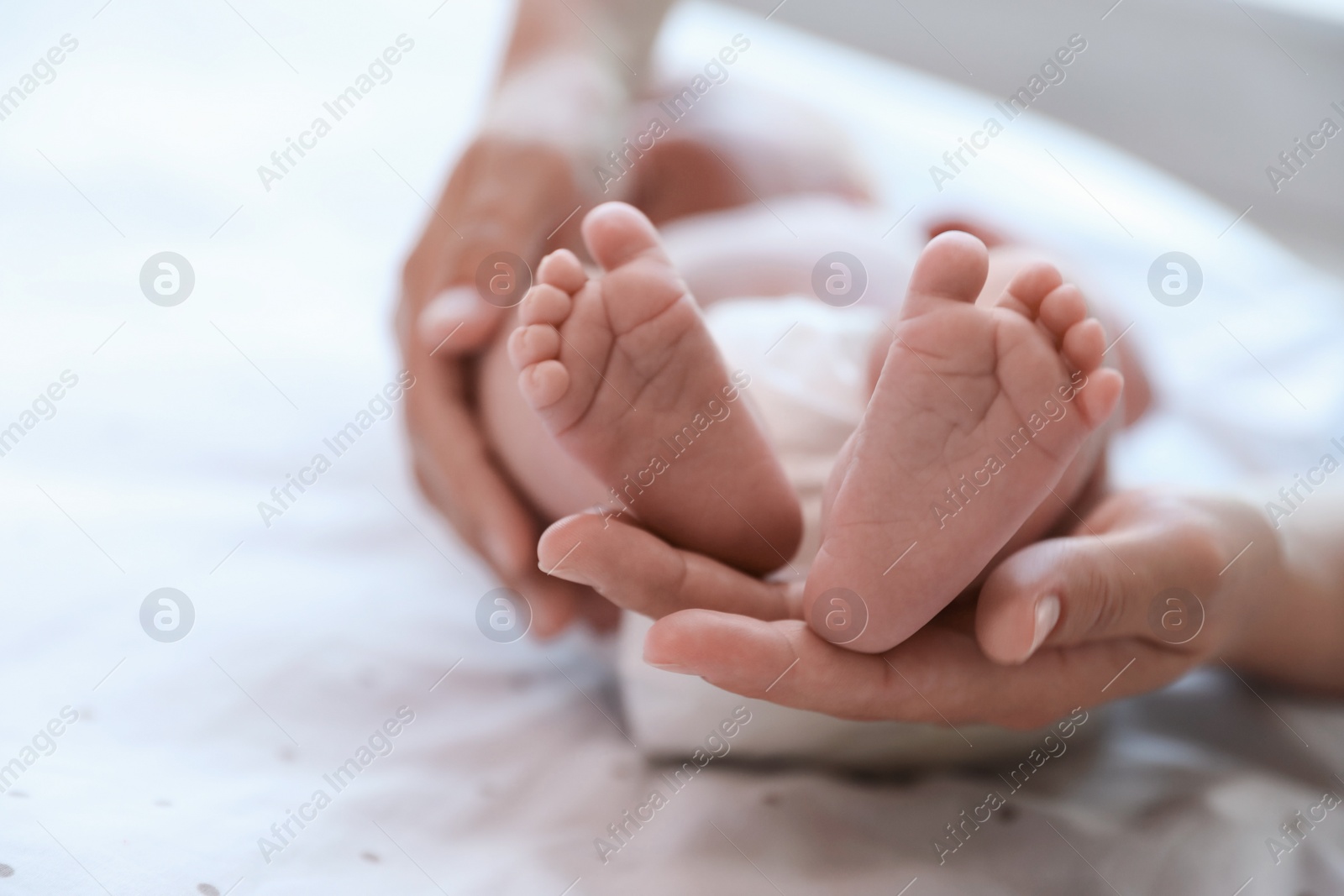 Photo of Mother and her newborn baby on bed, closeup