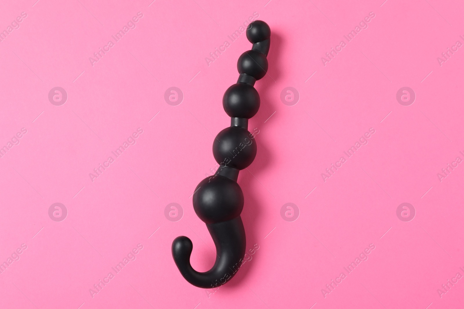 Photo of Black anal ball beads on pink background, top view. Sex toy