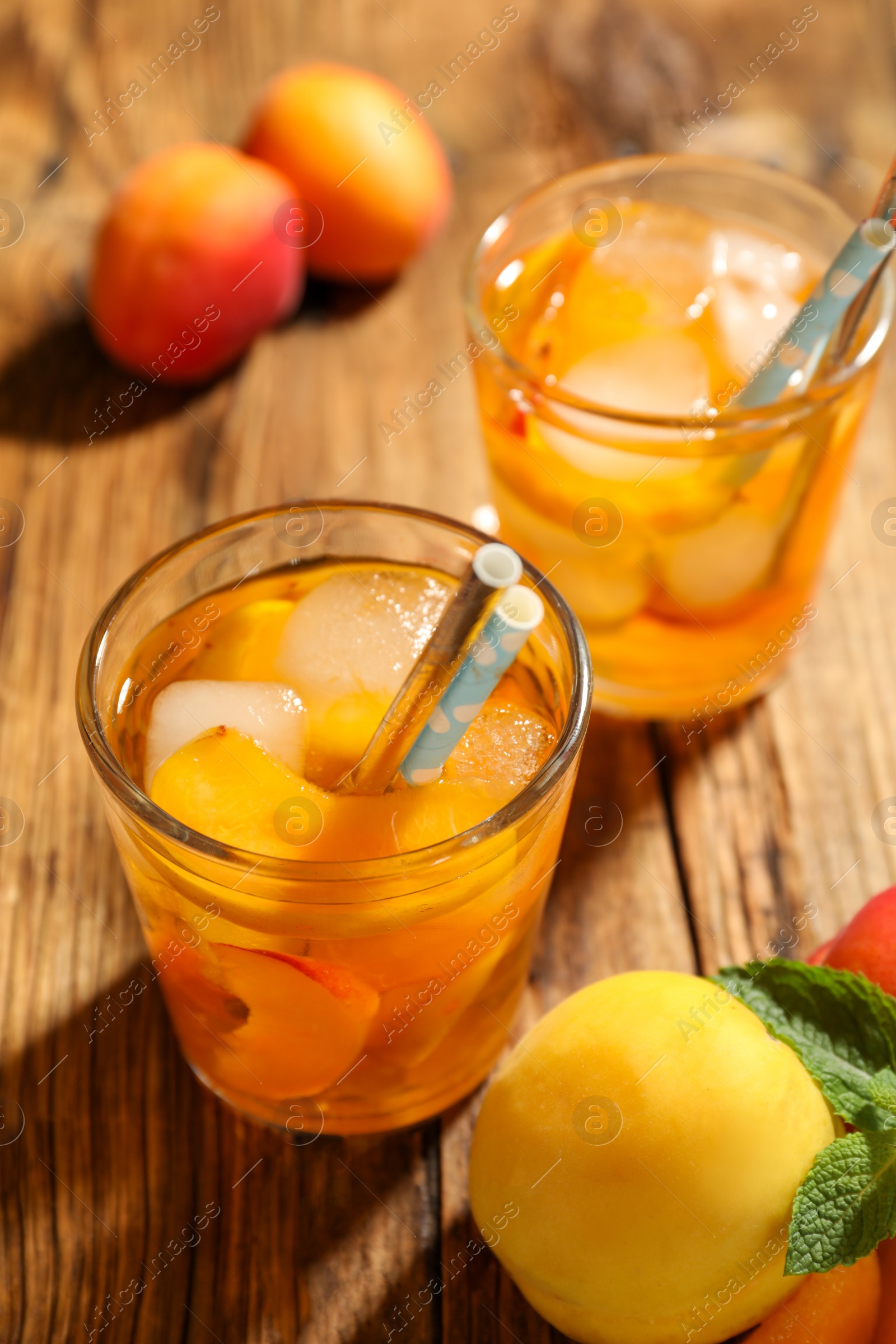Photo of Delicious refreshing drink with apricot on wooden table