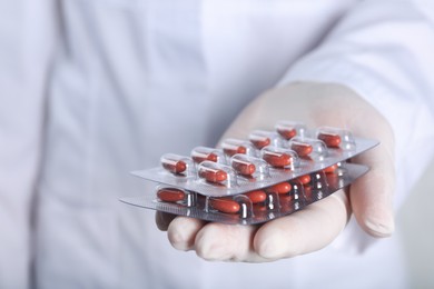 Photo of Doctor holding red pills, closeup. Anemia treatment