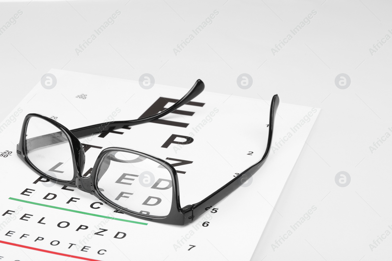 Photo of Glasses and vision test chart isolated on white