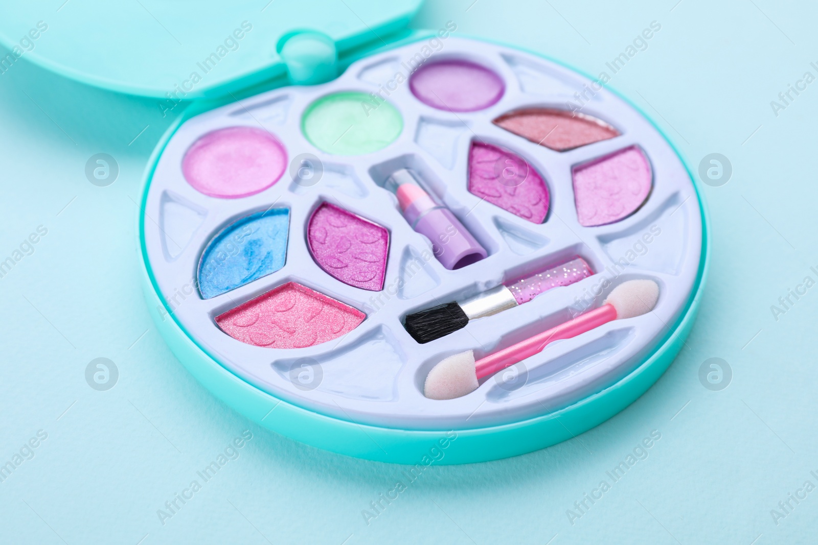 Photo of Decorative cosmetics for kids. Eye shadow palette on light blue background, closeup